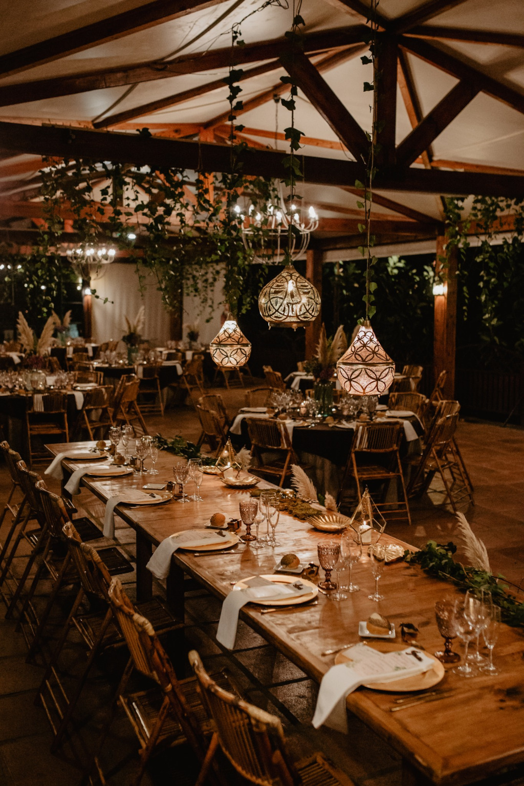 Mesa decorada para evento con vajilla y copas bajo lámparas colgantes en Tenerife.