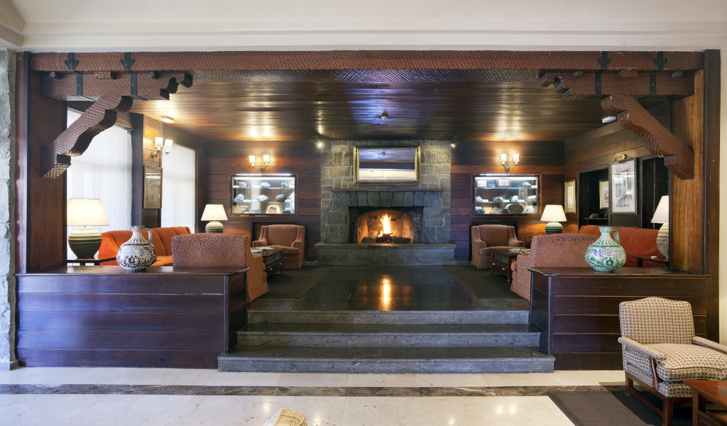 Sala de estar con chimenea, sofás y lámparas en hotel de Tenerife.