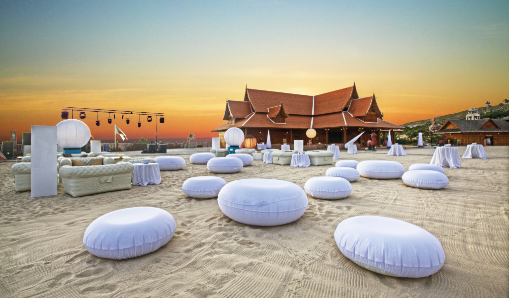 Cómodos cojines blancos en la playa al atardecer en Siam Park Tenerife.