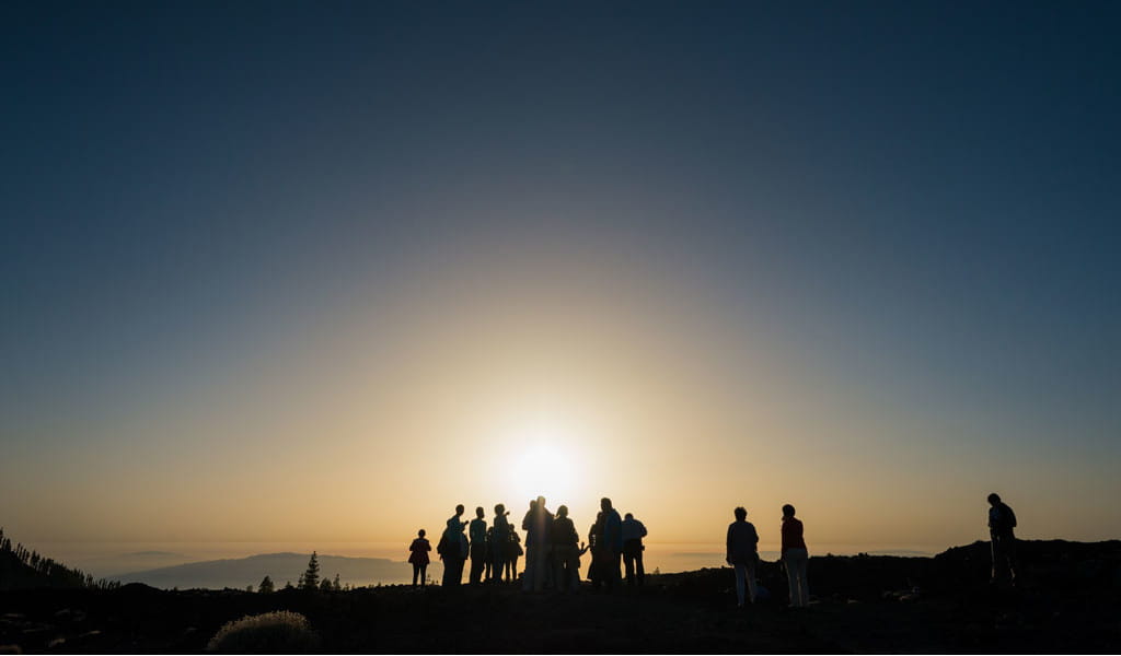 Grupo de personas observando la puesta del sol