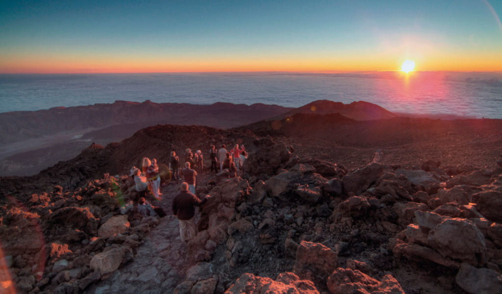 Grupo de personas reunidas en el parque nacional del Teide observando puesta del sol