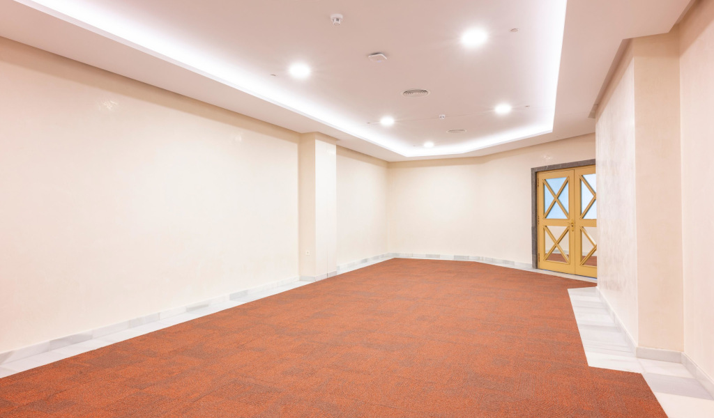 Sala con piso alfombrado y puertas dobles en un edificio en Tenerife.