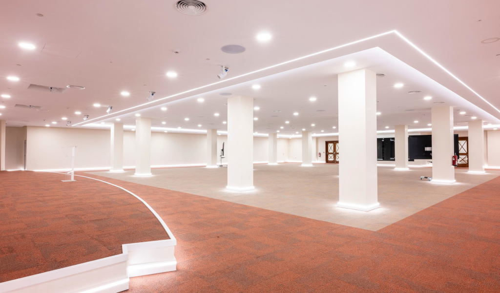 Sala amplia con columnas blancas y techo iluminado en un espacio moderno en Tenerife.