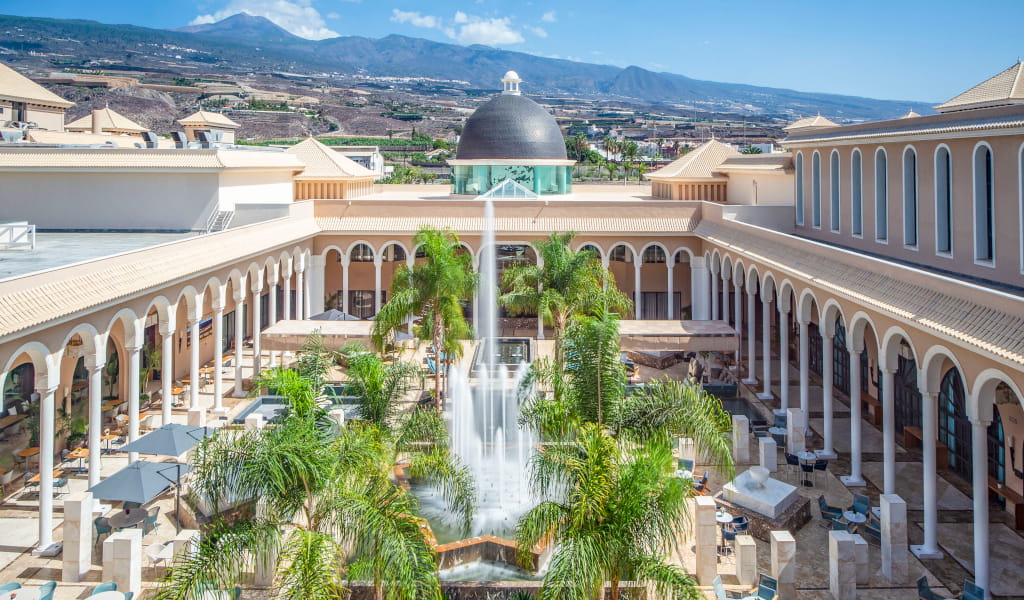 Patio con fuente y arcos rodeado de montañas en Tenerife.