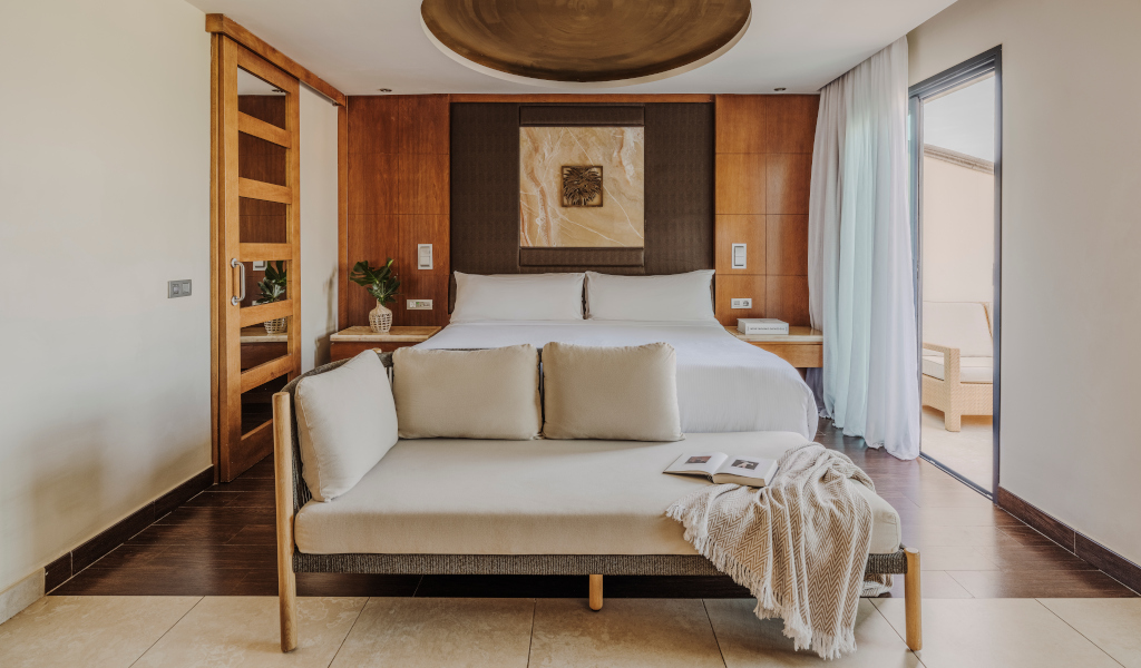 Habitación con cama doble, sofá y decoración en tonos neutros en Tenerife.