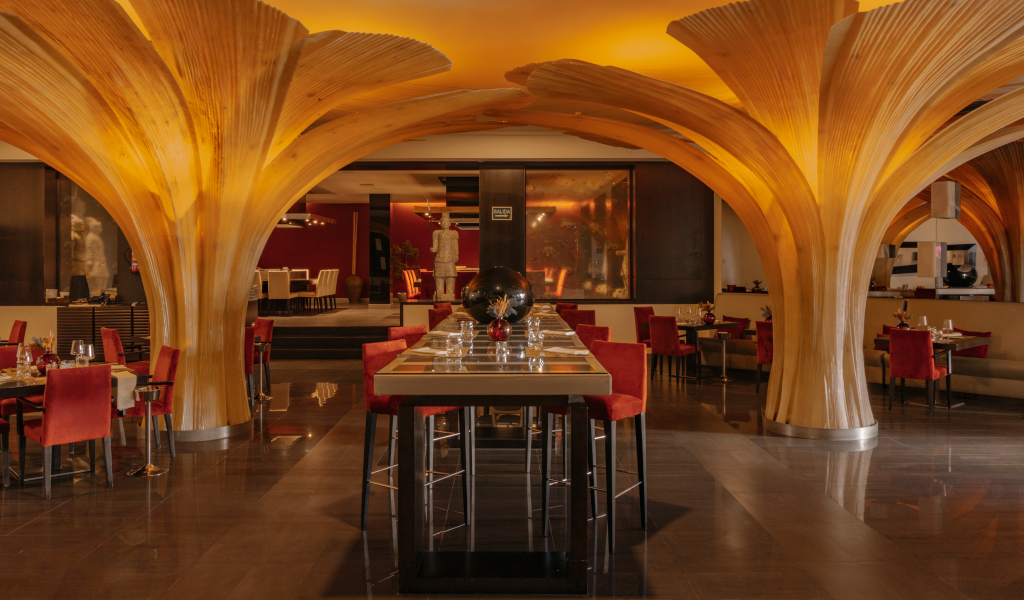 Restaurante con decoración de columnas de madera y sillas rojas en Tenerife.
