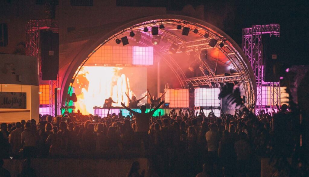 Concierto nocturno en Tenerife con multitud frente a escenario iluminado.