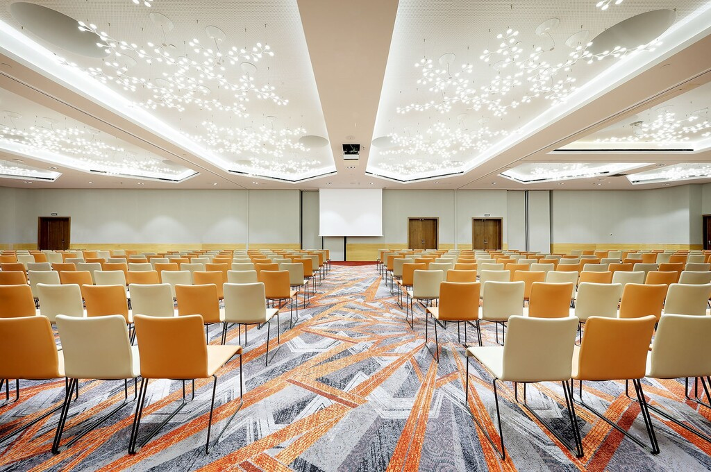 Sala de conferencias vacía en Tenerife con sillas alineadas y techo iluminado.