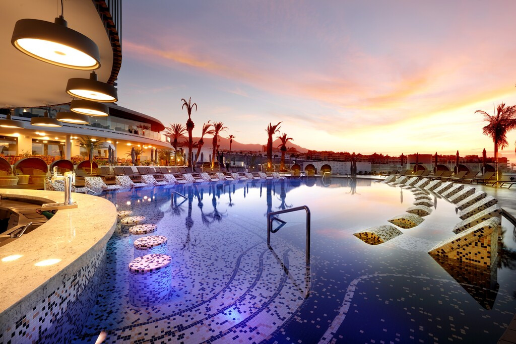 Piscina al atardecer en hotel de Tenerife, con iluminación moderna y tumbonas.