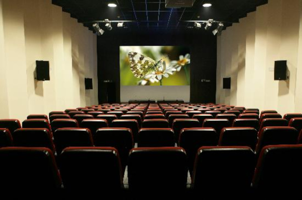 Sala de cine vacía en Tenerife con imagen de mariposa en pantalla.