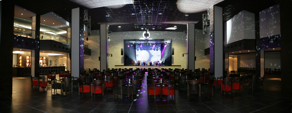 Sala de espectáculos con escenario iluminado y asientos vacíos en Tenerife.