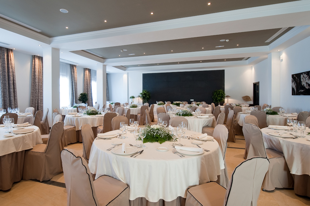 Salón de eventos con mesas redondas vestidas, ubicado en Tenerife.