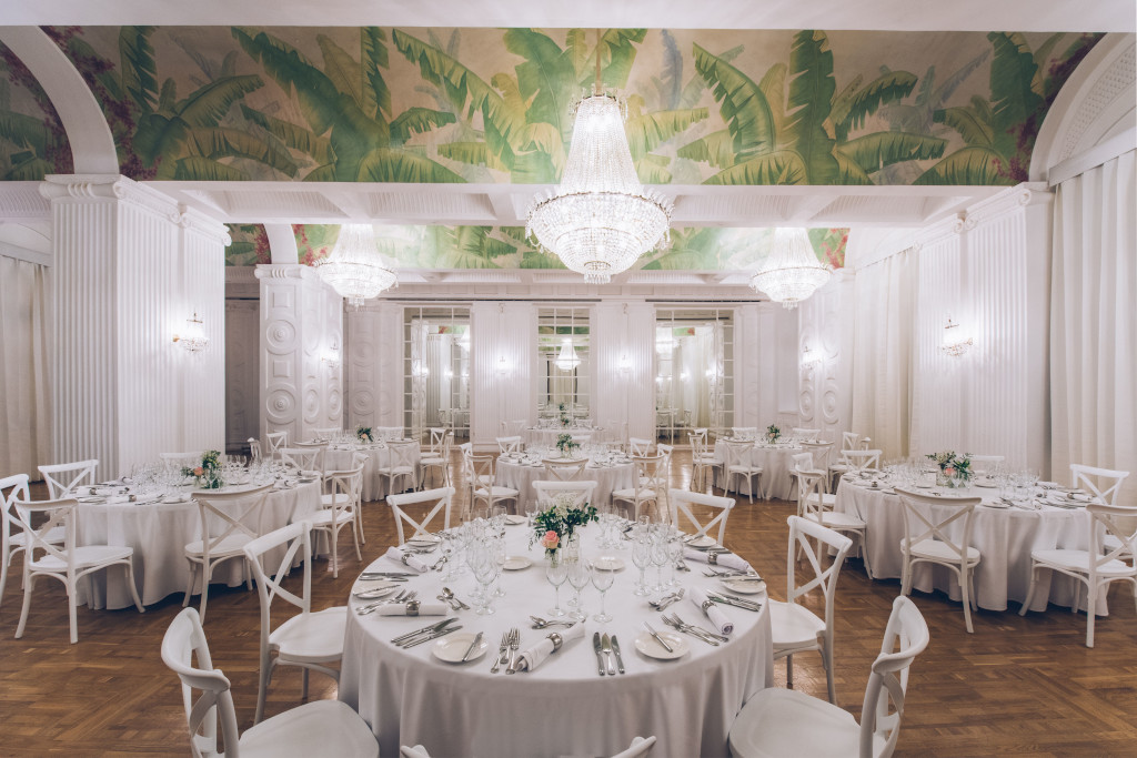 Sala decorada con mesas redondas y sillas blancas en un lugar de Tenerife.