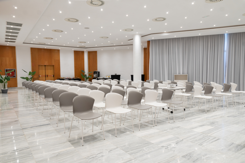 Sala de conferencias vacía con filas de sillas grises y blancas en Tenerife.