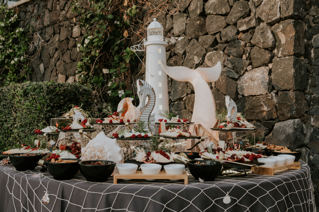 Mesa de dulces con decoración marina y faro en un lugar de Tenerife.