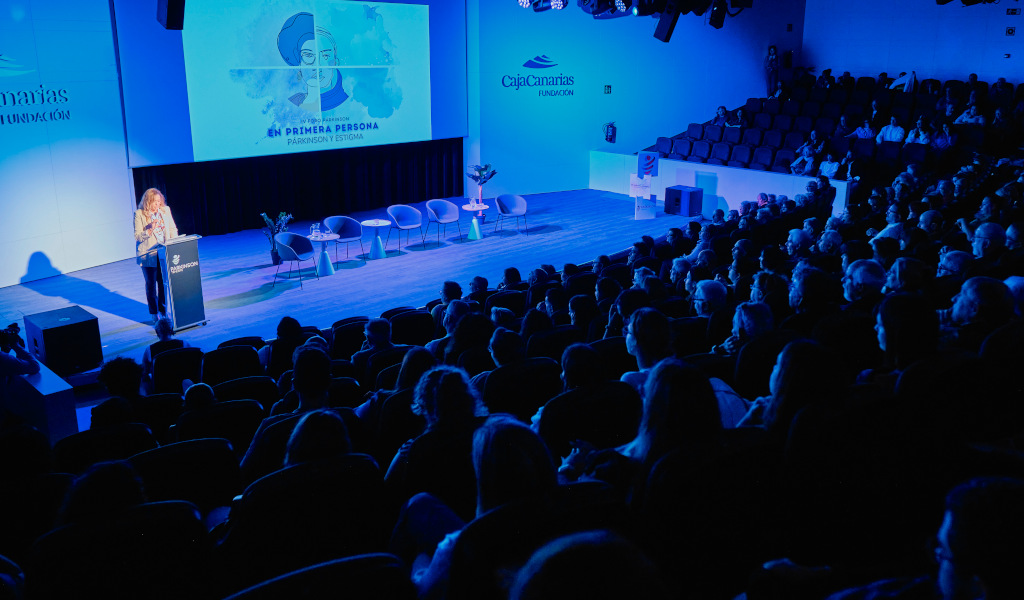 Auditorio en Tenerife con gente asistiendo a una presentación sobre Parkinson y Estigma.