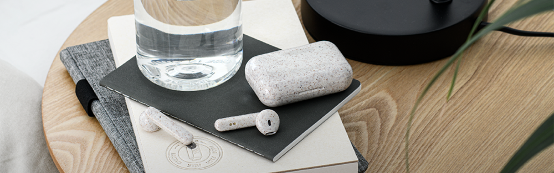 Auriculares y estuche sobre una mesa con botellas y libretas, en Santa Cruz de Tenerife.