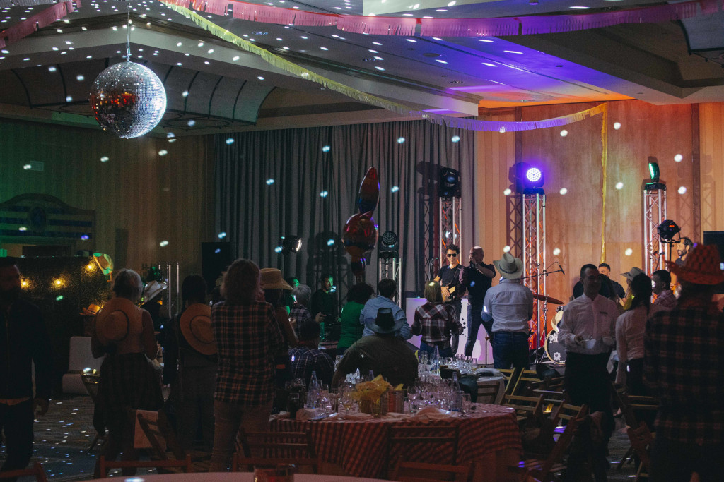 Personas disfrutando de una fiesta con luces y una bola de espejos en un salón en Tenerife.