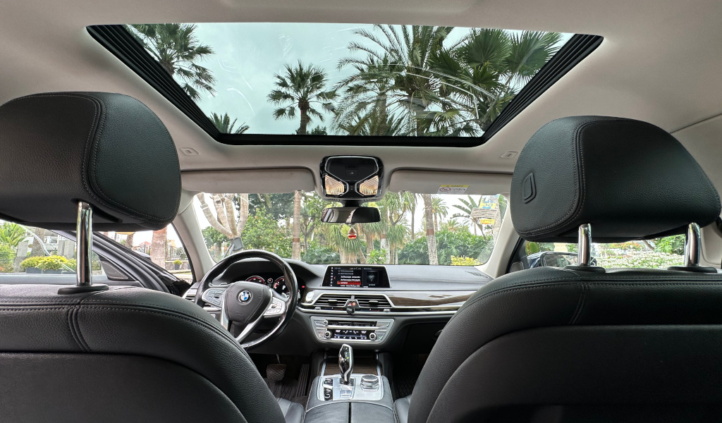 Interior de un automóvil con vista al cielo y palmeras en Tenerife.