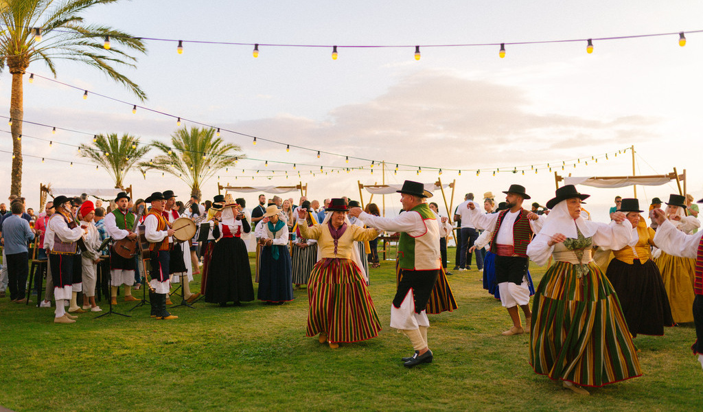 Personas bailando en trajes típicos durante festival en Tenerife.