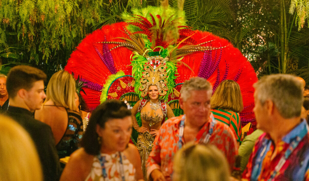 Persona con un colorido traje de carnaval rodeada de personas en Tenerife.