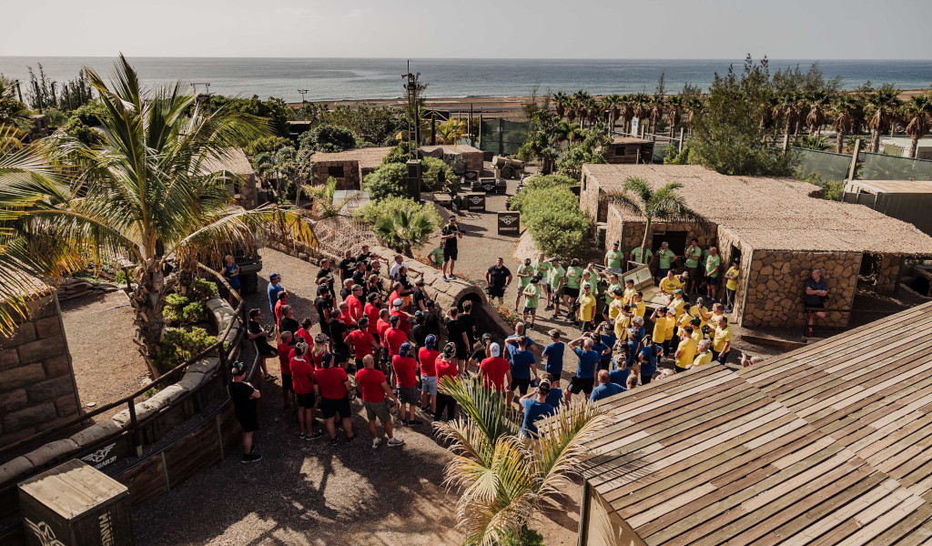 Personas reunidas en equipo bajo la luz del sol junto al mar en Tenerife.