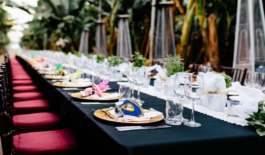 Mesa larga con platos decorativos y copas de vino en Tenerife