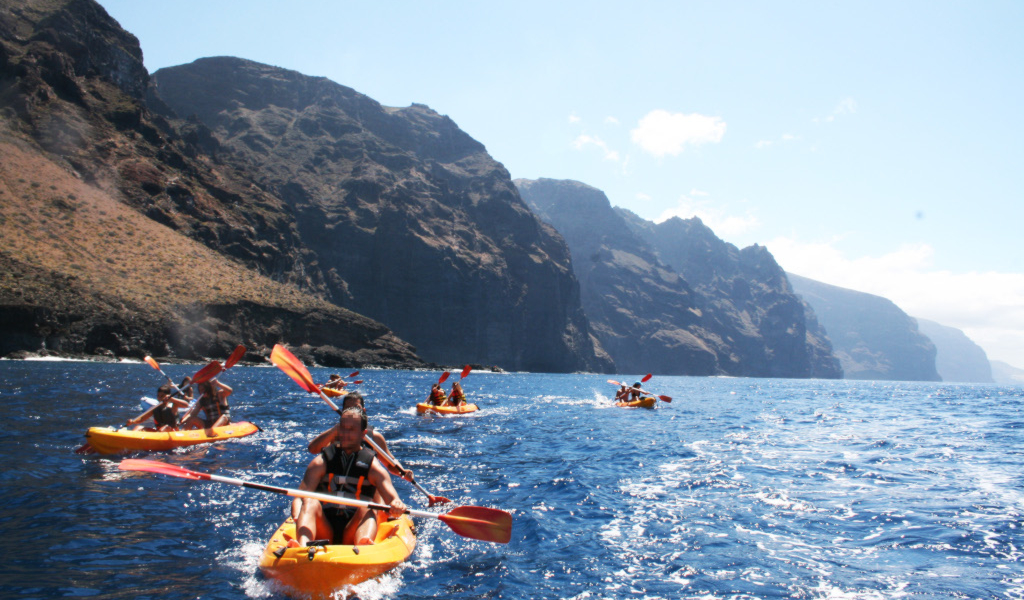 Personas practicando kayak frente a los acantilados de Los Gigantes