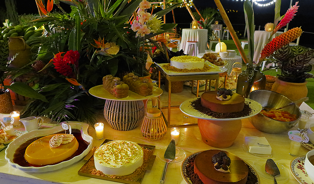 Postres variados sobre mesa decorada con flores en Tenerife.