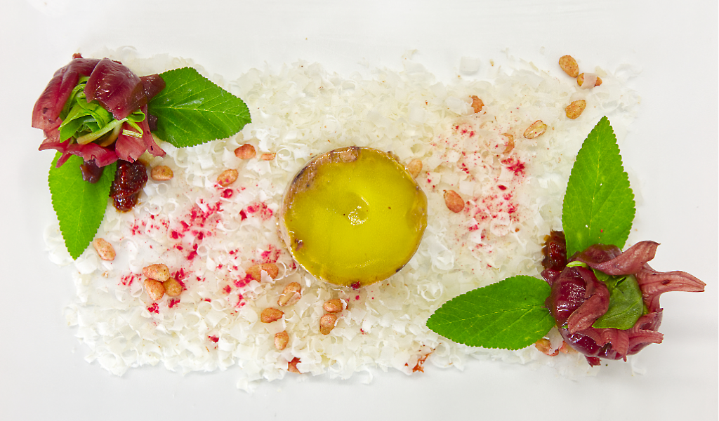 Plato gourmet con carne roja, hojas verdes y salsa en Tenerife.
