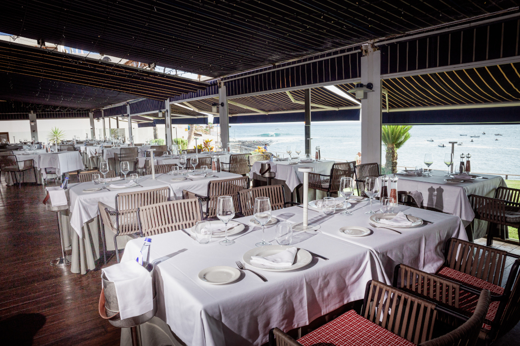 Restaurante con mesas preparadas frente al mar en Tenerife.