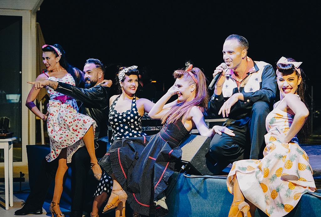 Grupo de personas posando y cantando en un evento nocturno en Tenerife.
