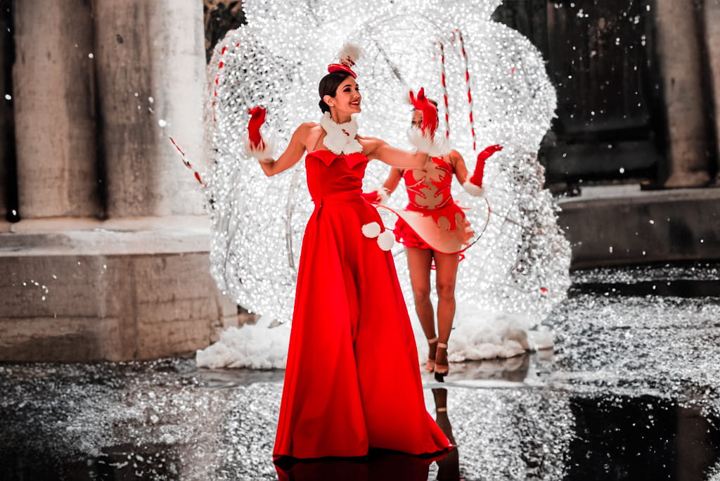 Persona con vestido rojo bailando junto a decoraciones luminosas navideñas en Tenerife.