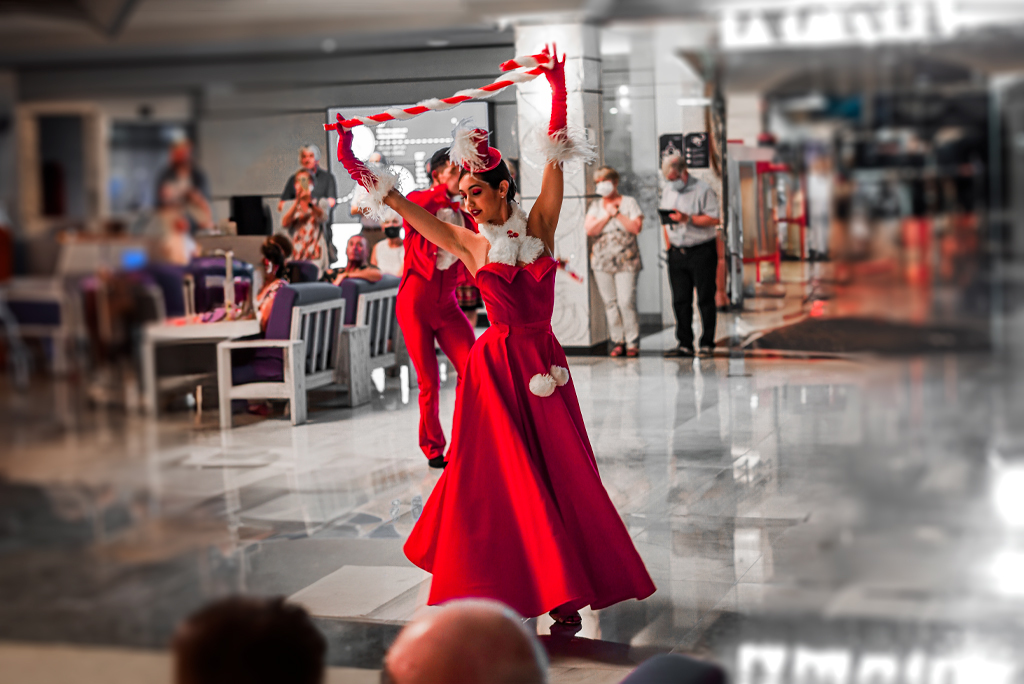 Bailarina con vestido rojo actuando en Tenerife, gente observando al fondo.