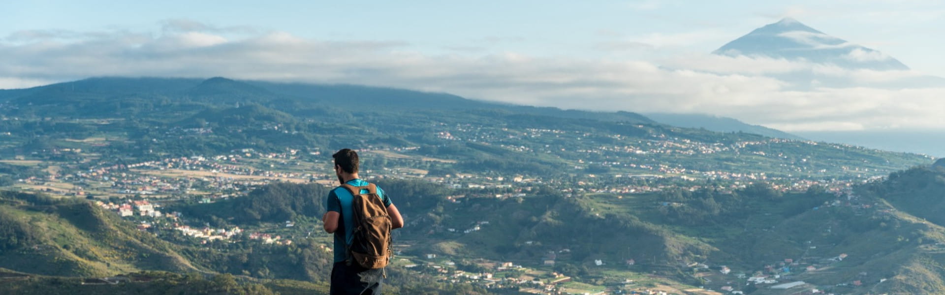 Persona mirando hacia paisaje montañoso de Tenerife con el Teide al fondo.