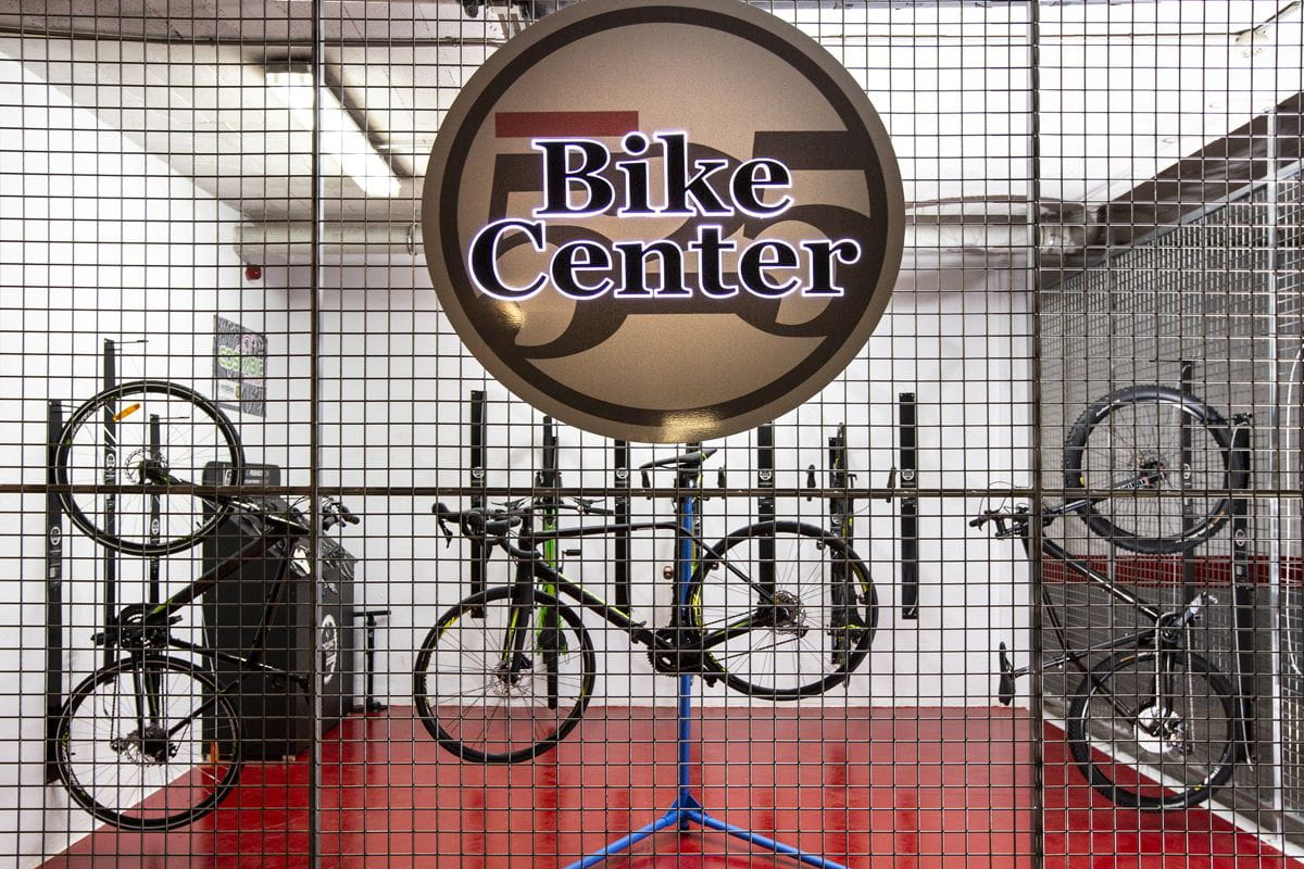 Bicicletas colgadas en un soporte, detrás de un cartel que dice Bike Center.