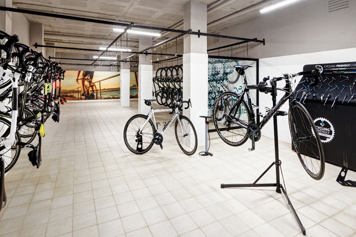Estacionamiento de bicicletas en Tenerife con mural de ciclista al fondo.