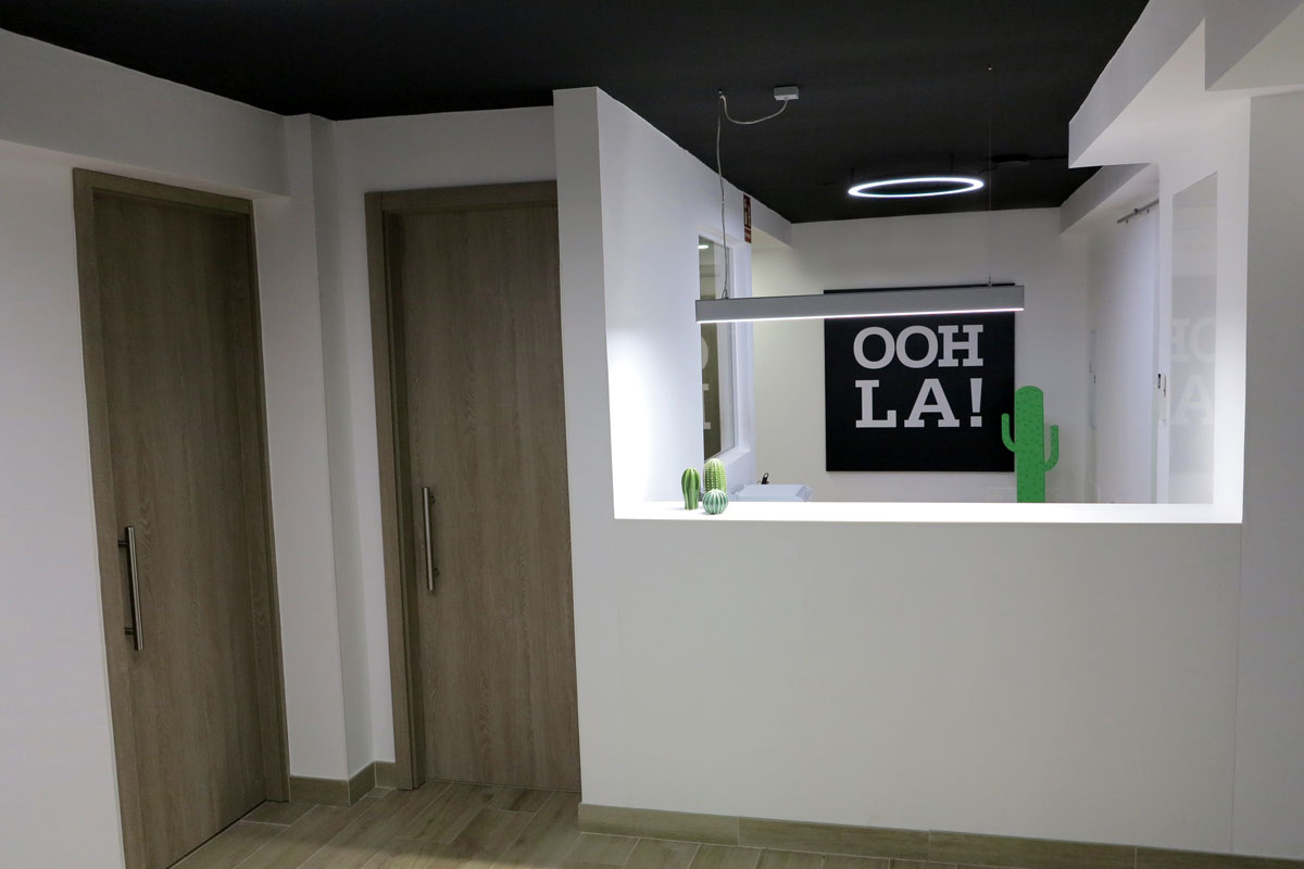 Recepción moderna con letrero OOH LA! y cactus decorativos en Tenerife.