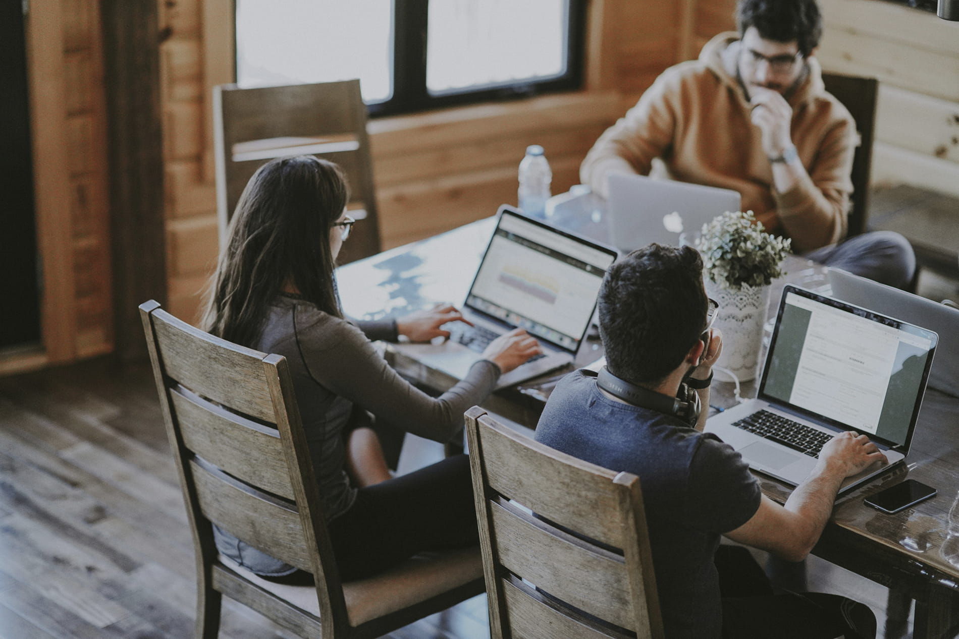 Tres personas jovenes reunidas con sus portatiles