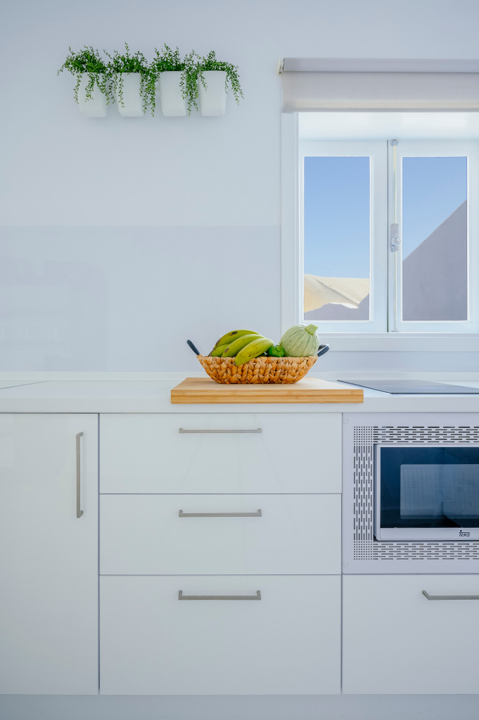 Cocina luminosa con cesta de frutas en encimera blanca en Tenerife.