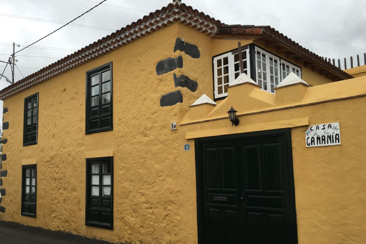 Casa de La Gañanía con fachada amarilla y ventanas negras en La Orotava, Tenerife.