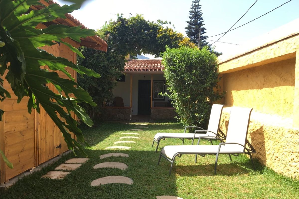 Jardín con sillones y camino de piedra en Tenerife.