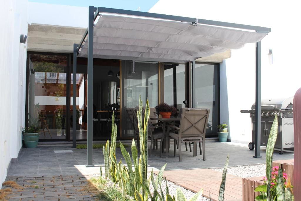 Terraza con mesa, sillas y pérgola en casa de Tenerife.