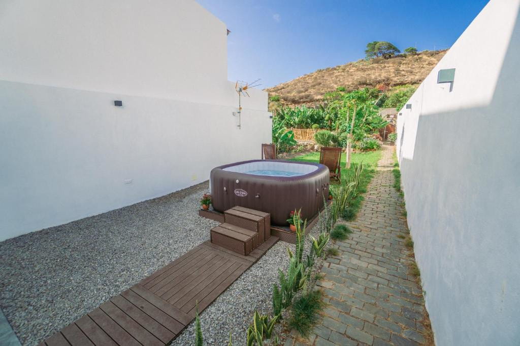 Jacuzzi al aire libre en un patio rodeado de paredes blancas en Tenerife.