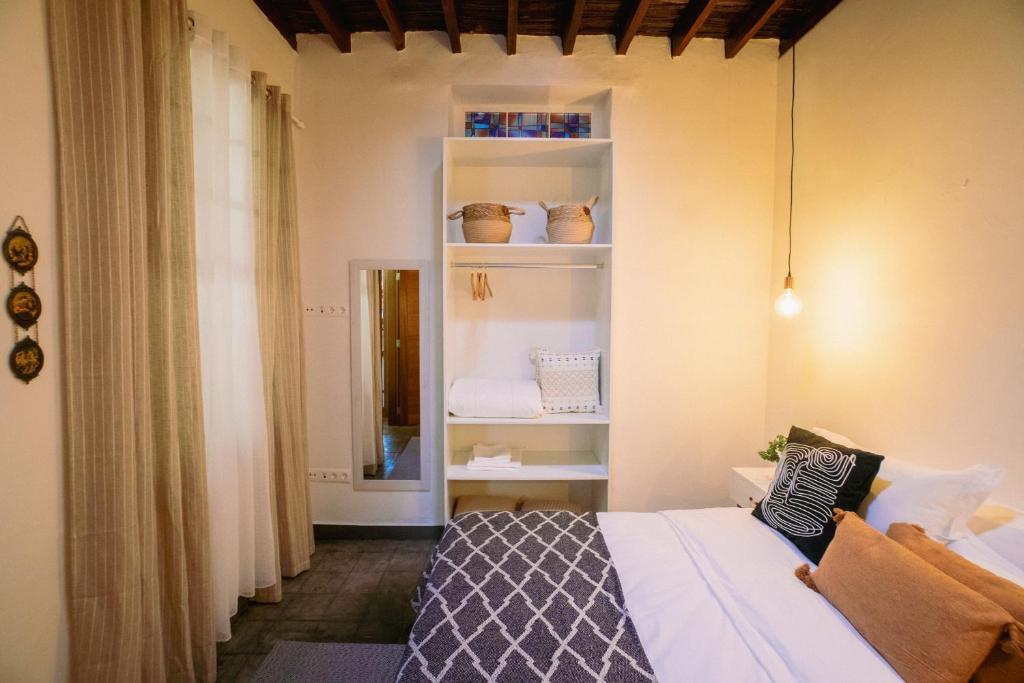 Habitación acogedora en Tenerife con cama, estante con toallas y decoración simple.