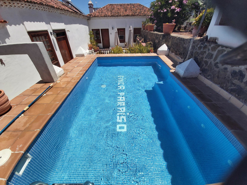 Piscina en casa rural con texto FINCA PARAÍSO en suelo, Tenerife.