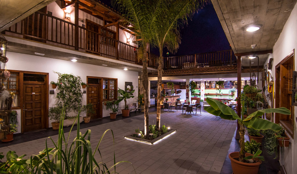 Patio interior iluminado de noche con plantas y mesas en La Orotava, Tenerife.