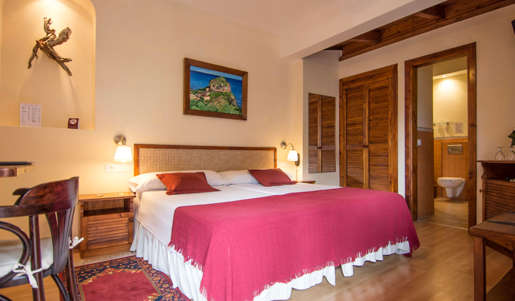 Habitación doble con baño en hotel de Tenerife, con cama grande y decoración cálida.