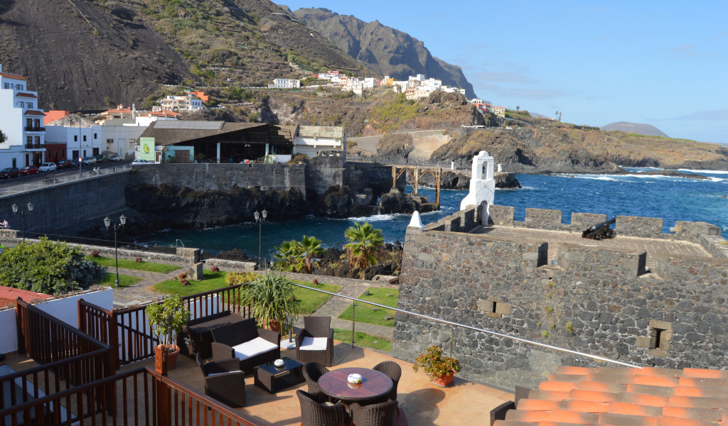 Vista costera de Garachico, Tenerife, con casas, mar y montañas al fondo.