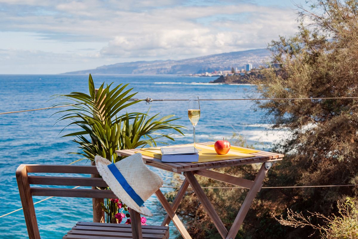 Mesa con copa de vino frente al mar en Tenerife.
